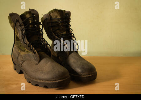 Old jungle boot still life on wood background Stock Photo