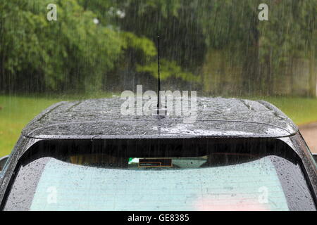 Heavy rain falling on a car roof Stock Photo