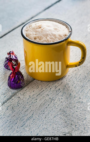 Yellow retro cup and chocolate candies. Stock Photo
