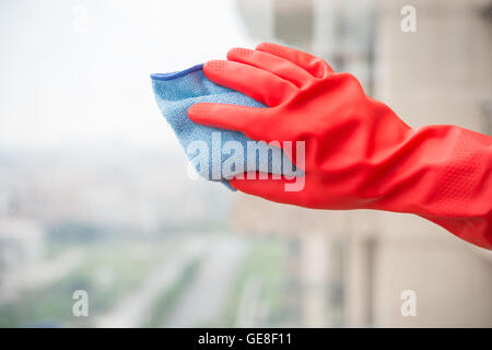 man cleaning the window with red glove Stock Photo
