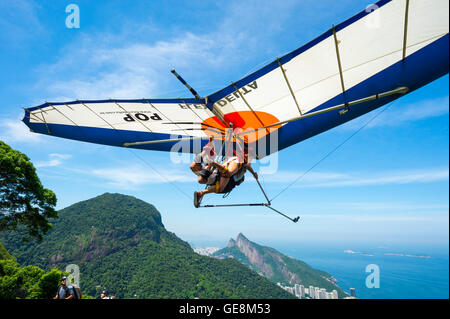 RIO DE JANEIRO - MARCH 22, 2016: A hang gliding instructor takes off with a passenger from Pedra Bonita. Stock Photo