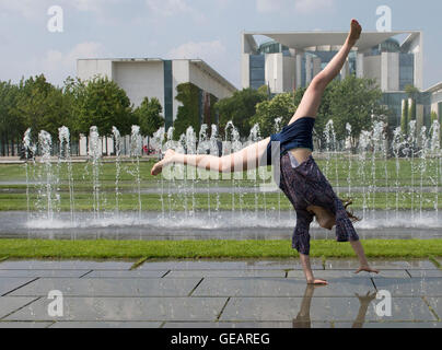 Berlin, Germany. 25th July, 2016. Kylie (14) from Hamburg does a cartwheel in front of the Chancellery in Berlin, Germany, 25 July 2016. Photo: Paul Zinken/dpa/Alamy Live News Stock Photo