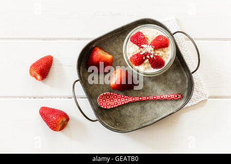 Glass of overnight oats with strawberries on metal tray Stock Photo