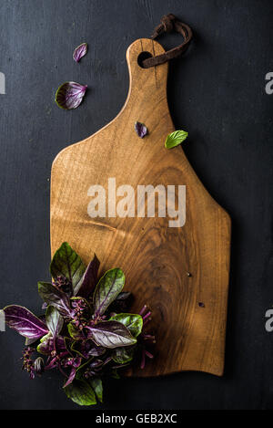 Violet basil bunch on wooden chopping board Stock Photo