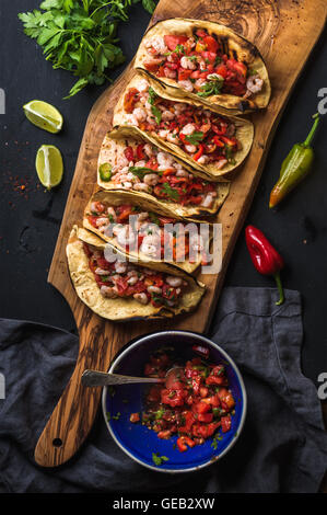 Shrimp tacos with homemade salsa, limes and parsley Stock Photo
