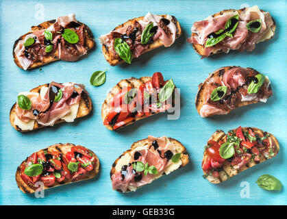 Brushetta snacks for wine. Variety of small sandwiches on turquoise blue backdrop Stock Photo