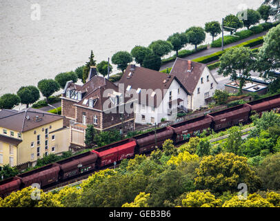 Freight train running directly next to private homes, without a noise barrier, river Rhine, Germany Stock Photo