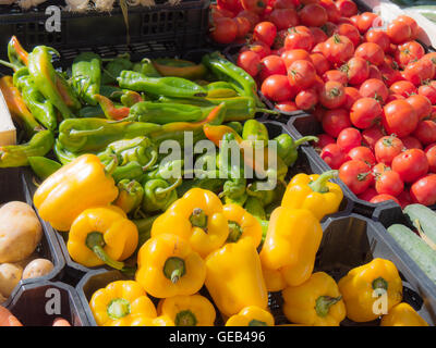 yellow and green peppers with tomatoes on the market Stock Photo