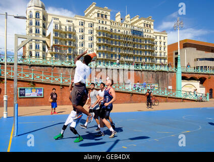 Young men playing basketball in front of the Grand Hotel on the lower esplanade in Brighton Stock Photo