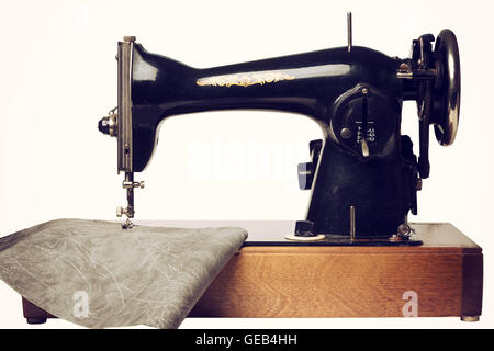 Retro sewing machine and gray leather isolated on white. Front view. Stock Photo
