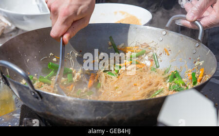 Street food. Noodles with vegetables fried in a frying pan. Stock Photo