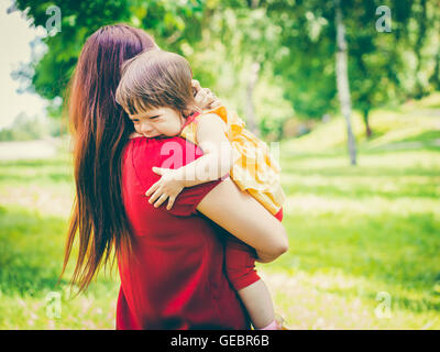 Mother holding her crying cute baby girl Stock Photo