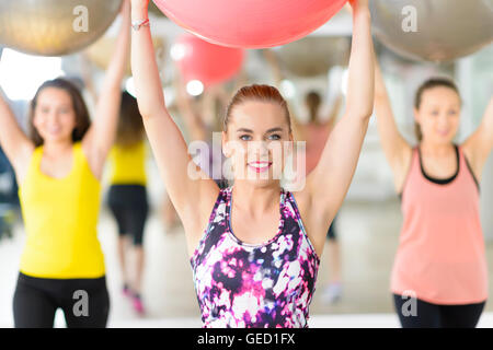 People exercising with fitness ball at gym Stock Photo