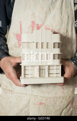 A plaster scale model of a known architectural building held with two hands of a person. Stock Photo