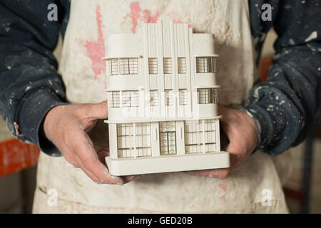Plaster Modeling Table Overhead of two plaster scale model buildings and their parts on a ...