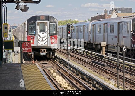 A number 7 elevated train approaching the 74th Street station in Jackson Heights Queens with a second train in the background. Stock Photo