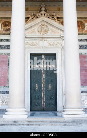 St Paul basilica holy door in Rome with column, closed door with big cross of the cathedral facade Stock Photo