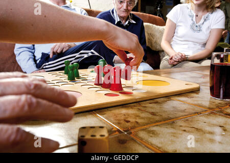 Senior citizens playing Ludo with over-sized game pieces at an old-age home Stock Photo
