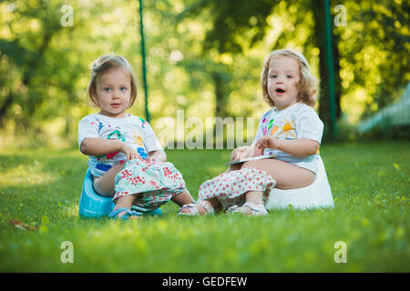 The two little baby girls hanging upside down Stock Photo