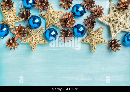 Christmas or new year decoration background: pine cones, blue glass balls, golden stars on painted backdrop, copy space Stock Photo