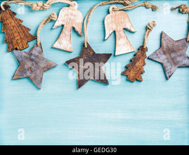 New Year or Christmas background: wooden angels, stars and small fir-trees over blue painted  backdrop, copy space Stock Photo