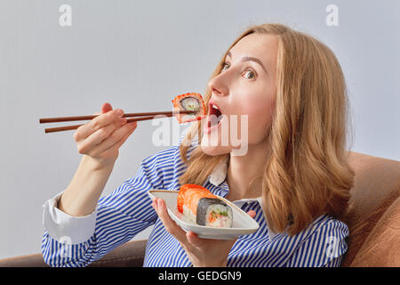 fun young woman eating sushi Stock Photo