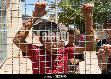 A boy looks into Arizona from Mexico at the border between Naco, Arizona, USA and Naco, Sonora, Mexico at the port-of-entry. Stock Photo