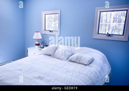 Bedroom with blue walls and windows in Wellfleet, MA on Cape Cod house. Stock Photo