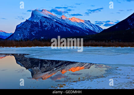 geography / travel, Canada, Alberta, 4 km W of Banff, View with reflections (from left to right) of the Fairholme Mountain Range (2995 metres/9825 feet), Tunnel Mountain (1692 metres/5551 feet), and Mount Rundle (2949 metres/9675 feet) over the partially Stock Photo