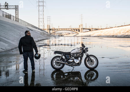 Man Standing with Motorcycle on Los Angeles River, Los Angeles, California, USA Stock Photo