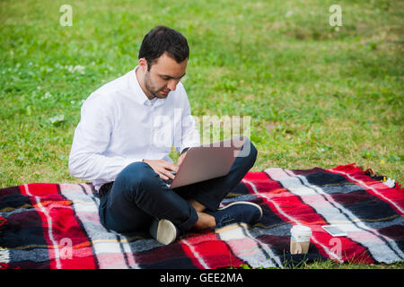 Thoughtful businessman in the field. With laptop Stock Photo