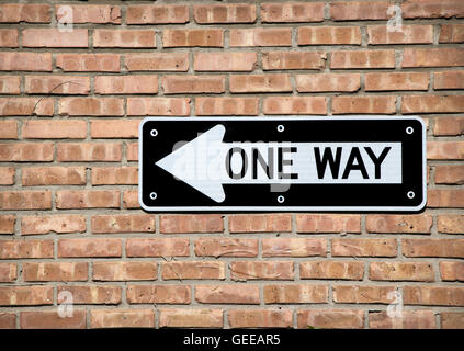 One way sign against a brick wall Stock Photo