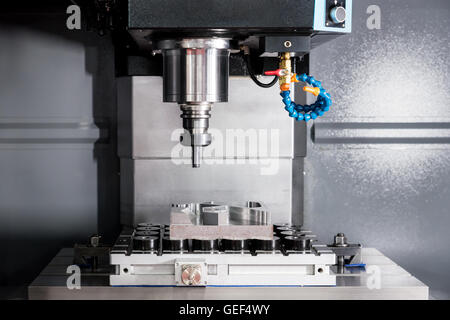 EDM or CNC industry machine working with coolant injection in industry factory. Low light. Stock Photo