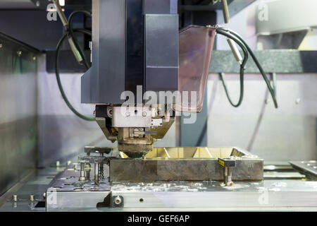Industrial machine - EDM Industrial machine working with coolant injection in factory. Close up at Industrial machine. Stock Photo
