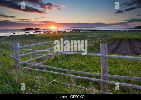 geography / travel, Canada, Newfoundland, L'Anse aux Meadows, Rustic fence at the end of the peninsula in the town of L'Anse aux Meadows at sunset backdropped by the Atlantic Ocean and rugged islands, Northern Peninsula, Great Northern Peninsula, Viking T Stock Photo