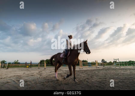 Young pretty girl riding a horse Stock Photo