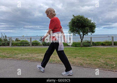 Woman walking along the seafront in Falmouth, UK Stock Photo
