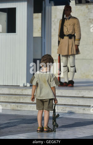 Evzone guarding the Tomb of the Unknown Soldier in Athens being copied by a small boy. Greece. Europe Stock Photo