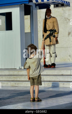 Evzone guarding the Tomb of the Unknown Soldier in Athens being copied by a small boy. Greece. Europe Stock Photo