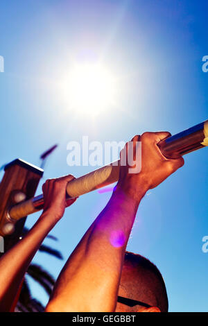 closeup of a young caucasian sportsman wearing sunglasses doing pull-ups outdoors Stock Photo