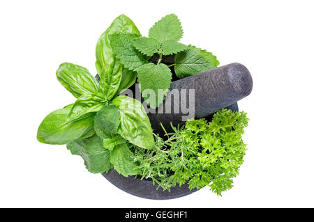 Top view of a massive gray granite mortar and pestle with herbs inside isolated on white Stock Photo