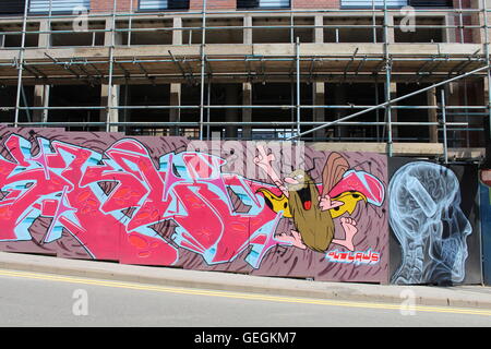 Graffiti on side of a building site with scaffolding in Sheffield, England Stock Photo