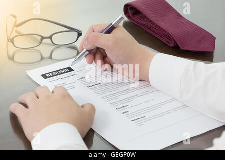Business man review his resume on his desk or job seeker review his resume before sending to finding a new job. Resume informati Stock Photo