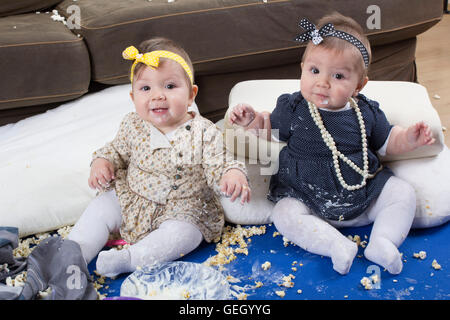 introducing food to baby, happy twin babies making a mess Stock Photo