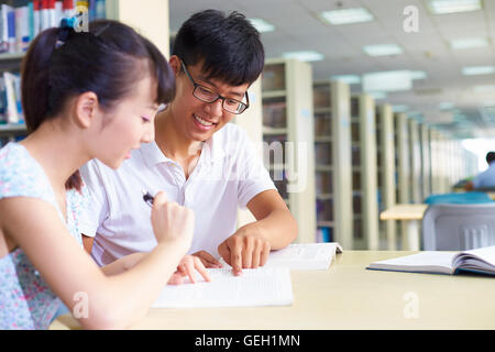 Young asian or Chinese college students study together in the library Stock Photo
