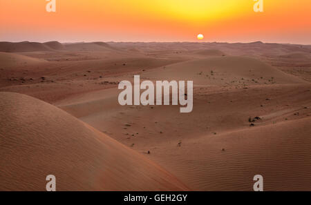 Sun rising over dunes of Dubai Desert Conservation Reserve, UAE Stock Photo