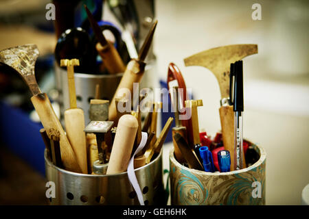Metal pots full of hand tools for skilled work, for book binding tasks. Stock Photo