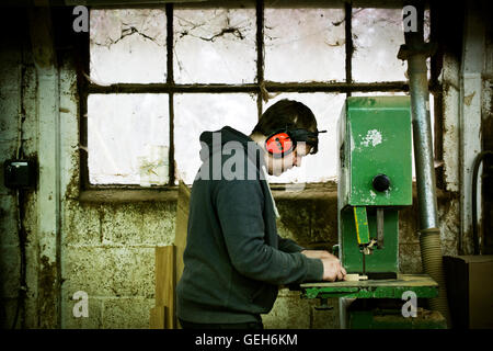 A man working in a furniture maker's workshop. Stock Photo