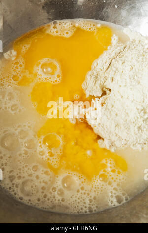 Close up of bread dough in a metal mixing bowl, flour, water and eggs. Stock Photo