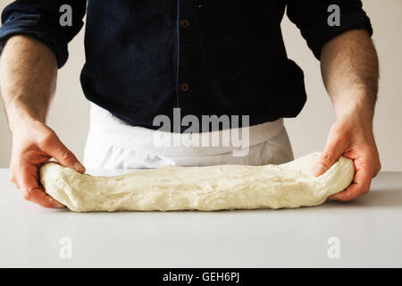 Close up of a baker kneading bread dough. Stock Photo